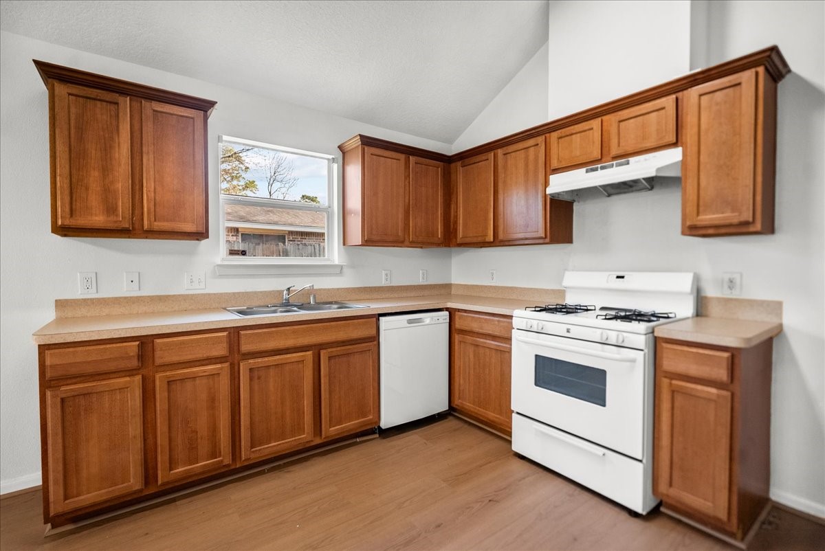 726 Flying Bridge Way Crosby, TX 77532 - Photo 11 of 32 a kitchen with granite countertop wooden cabinets and white appliances
