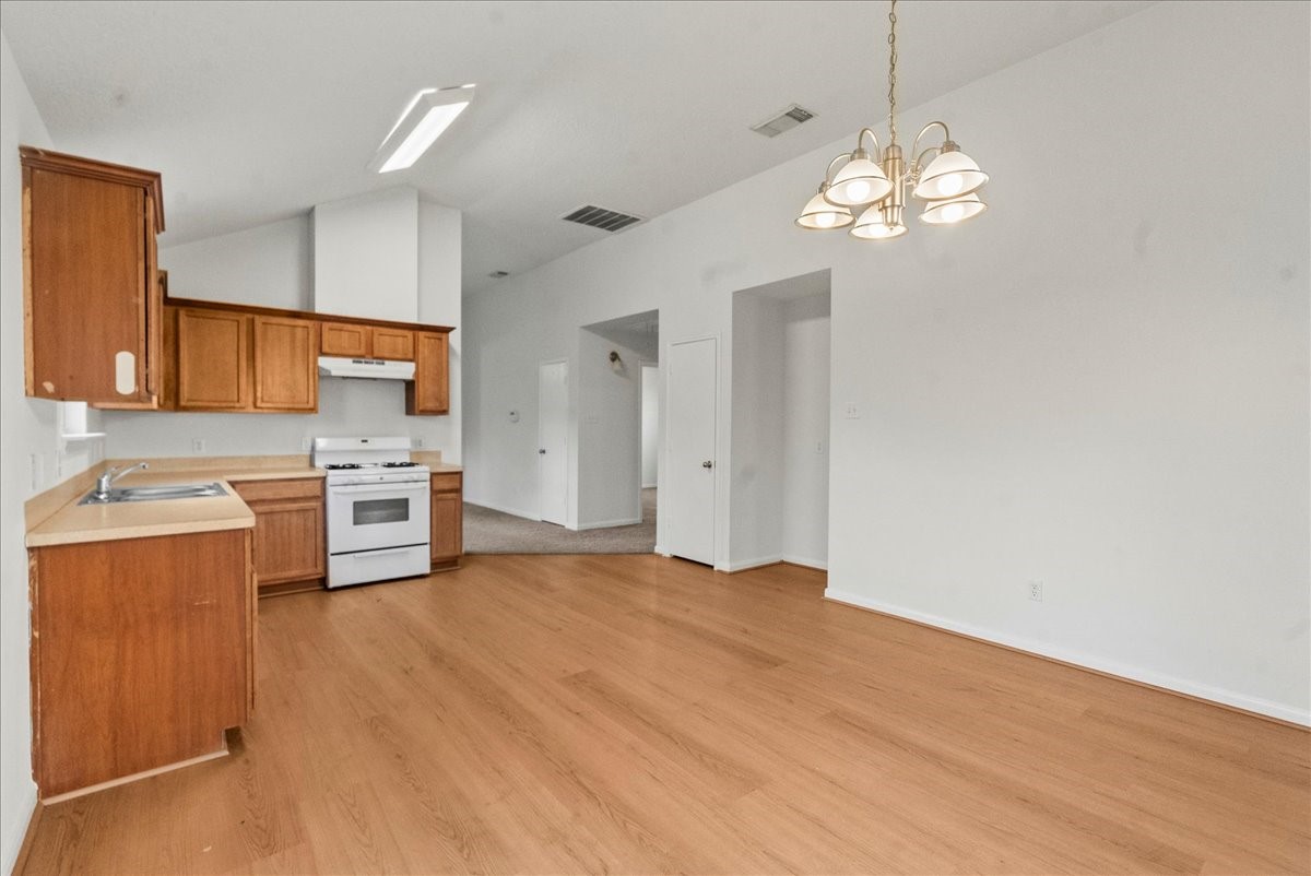 726 Flying Bridge Way Crosby, TX 77532 - Photo 32 of 32 a view of a kitchen with a sink and dishwasher a stove top oven with wooden floor