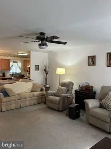 a living room with furniture and a ceiling fan