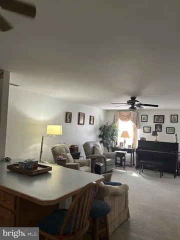 a living room with furniture a piano and a fireplace