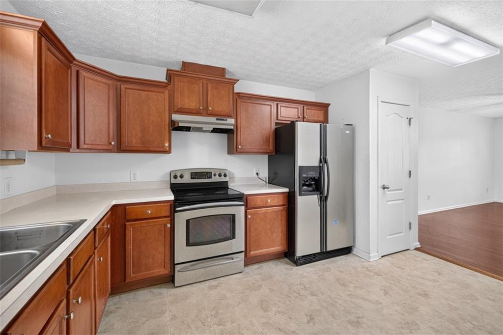 602 Pendergrass Road Winder, GA 30680 - Photo 18 of 44 a kitchen with stainless steel appliances granite countertop a refrigerator stove and sink