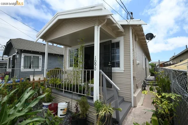 a view of a small house with wooden fence