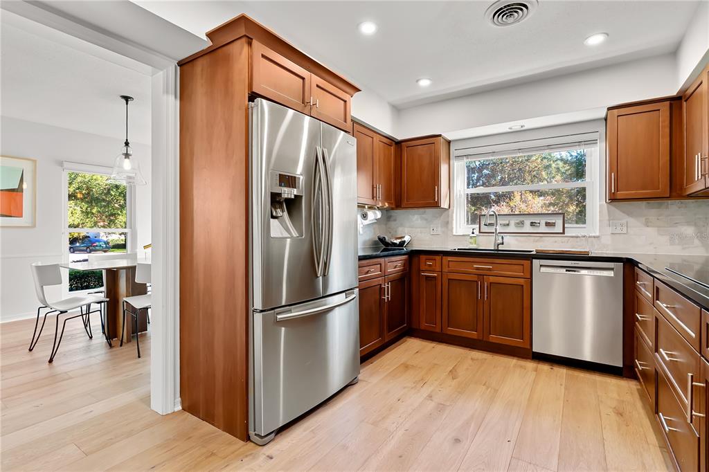 850 Juanita Rael Road Winter Park, FL 32789 - Photo 11 of 50 a kitchen with granite countertop stainless steel appliances a refrigerator cabinets and wooden floor
