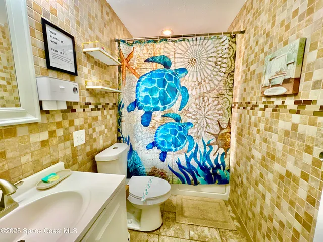 a bathroom with a sink toilet and shower curtain
