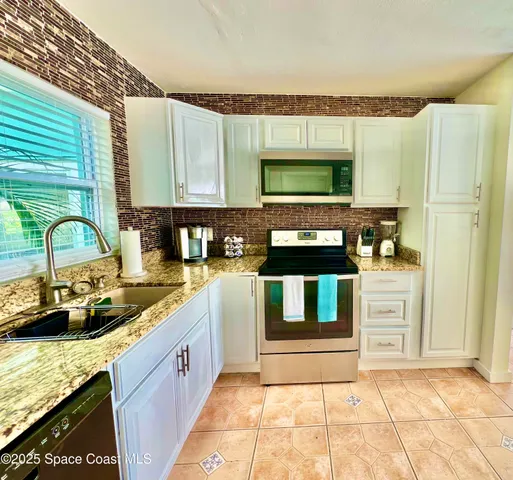 a kitchen with stainless steel appliances granite countertop a sink stove and cabinets