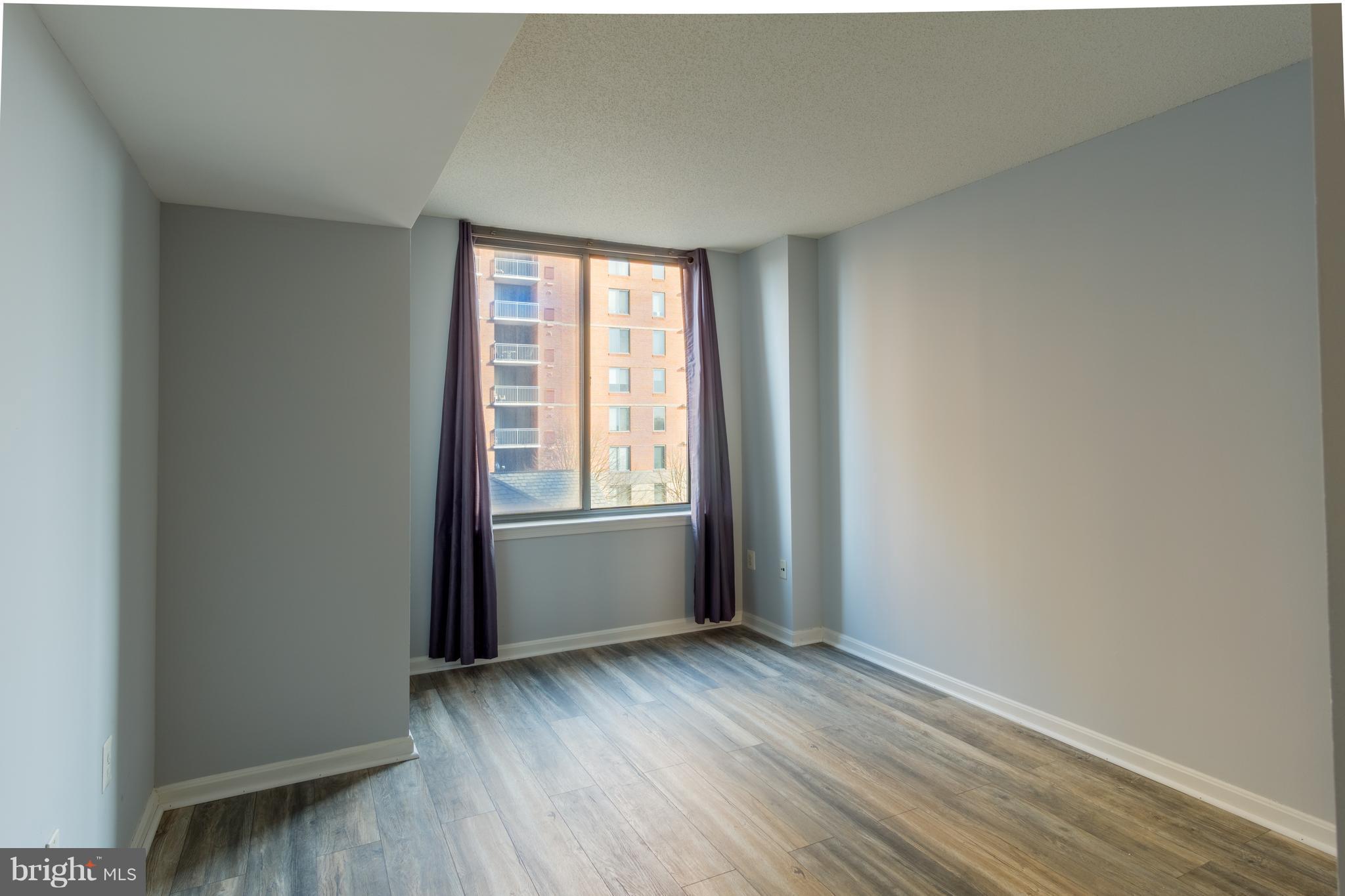 11710 Old Georgetown Road, Unit 422 North Bethesda, MD 20852 - Photo 12 of 29 an empty room with wooden floor and windows