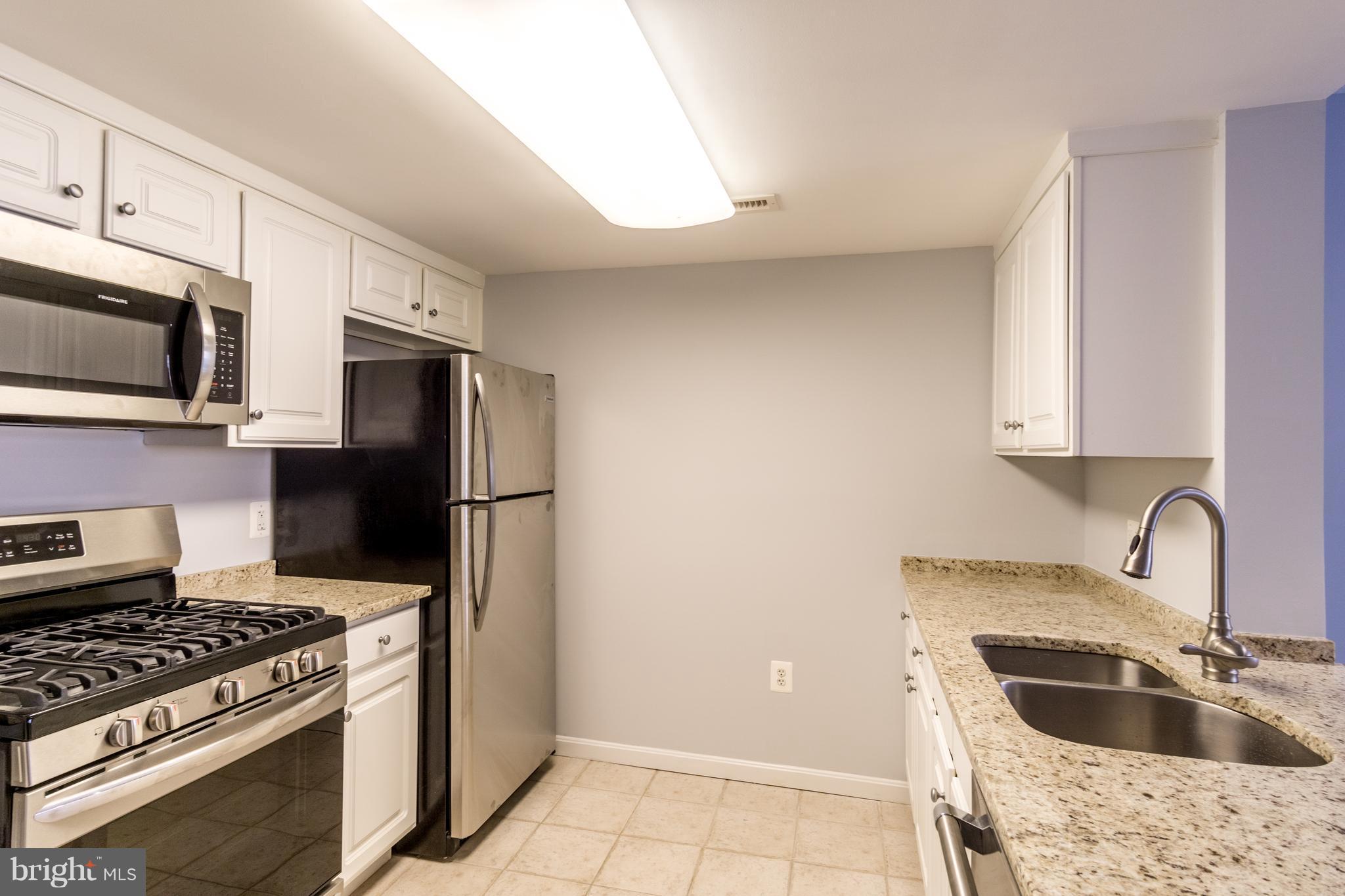 11710 Old Georgetown Road, Unit 422 North Bethesda, MD 20852 - Photo 4 of 29 a kitchen with stainless steel appliances granite countertop a sink stove a refrigerator and microwave