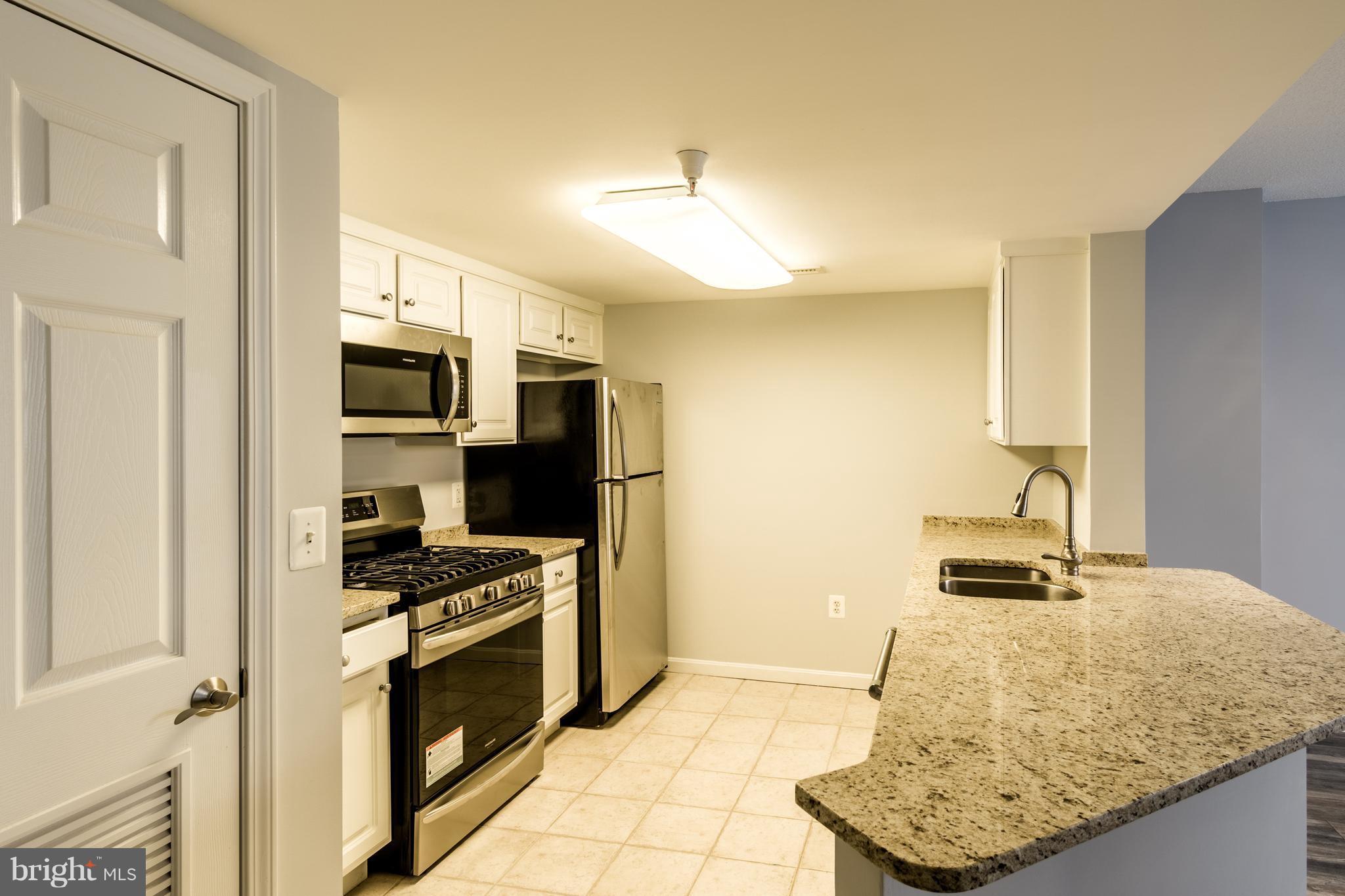 11710 Old Georgetown Road, Unit 422 North Bethesda, MD 20852 - Photo 5 of 29 a kitchen with stainless steel appliances granite countertop a stove and a refrigerator