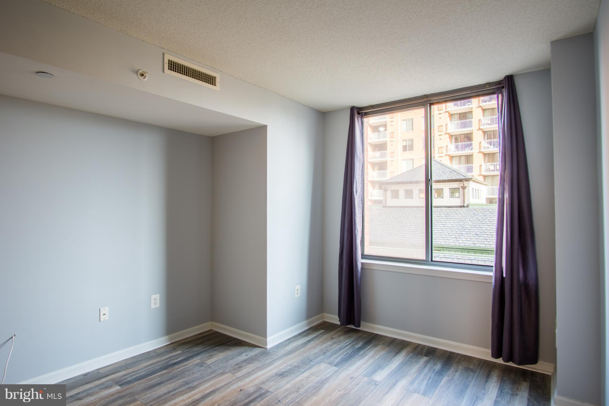 11710 Old Georgetown Road, Unit 422 North Bethesda, MD 20852 - Photo 10 of 29 a view of an empty room with wooden floor and a window