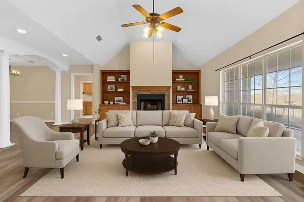 a living room with furniture fireplace and a large window