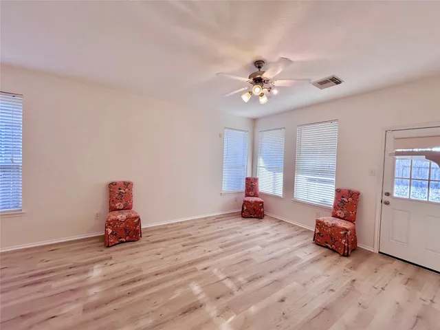 a view of a room with wooden floor and ceiling fan