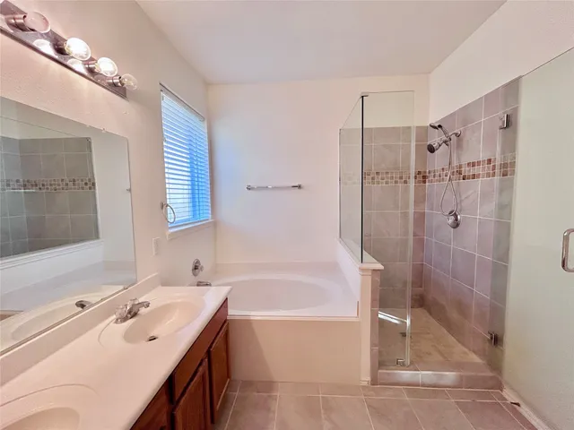 a bathroom with a tub sink shower and mirror