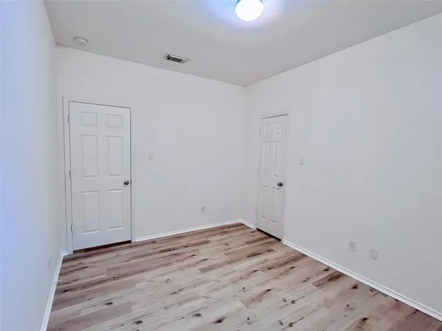 a view of a room with wooden floor and white walls