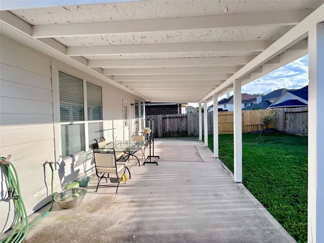a view of a patio with table and chairs potted plants with wooden fence