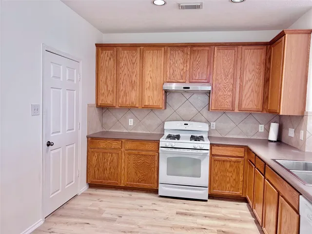 a kitchen with stainless steel appliances granite countertop a stove a sink and a refrigerator