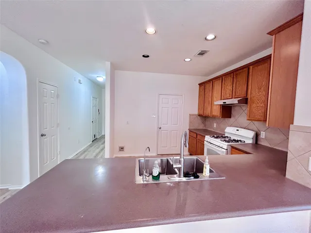 a living room with furniture and a kitchen