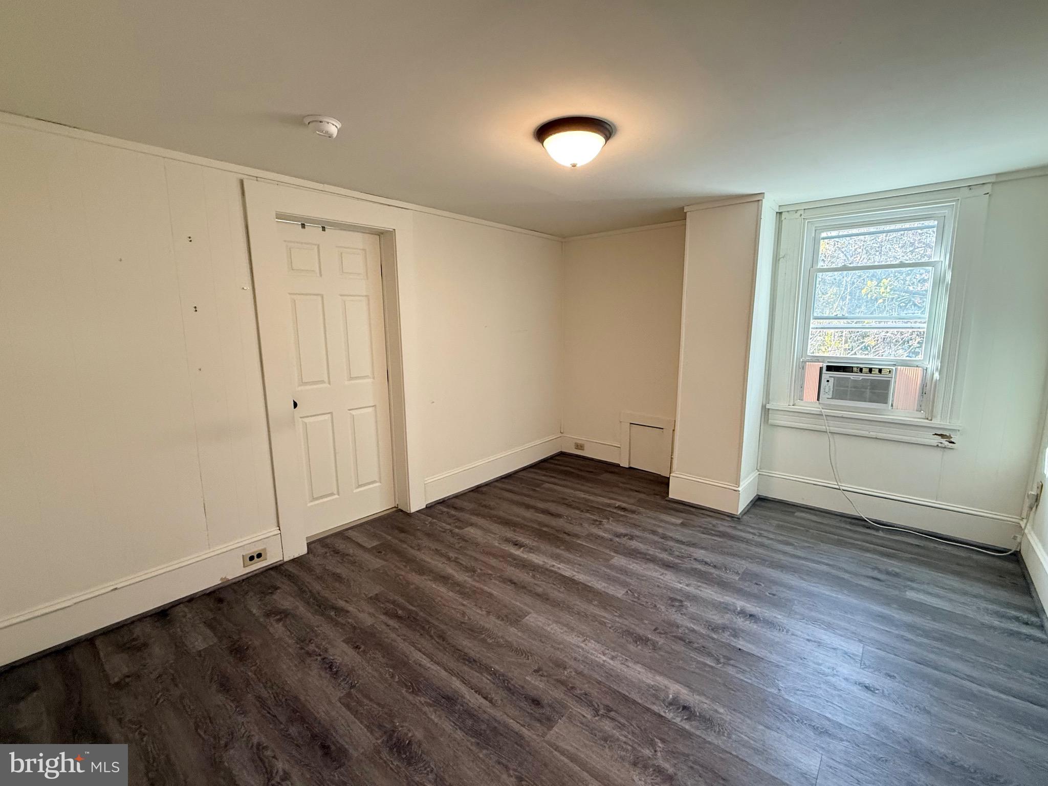 305 Central Avenue Ridgely, MD 21660 - Photo 16 of 19 an empty room with wooden floor and windows