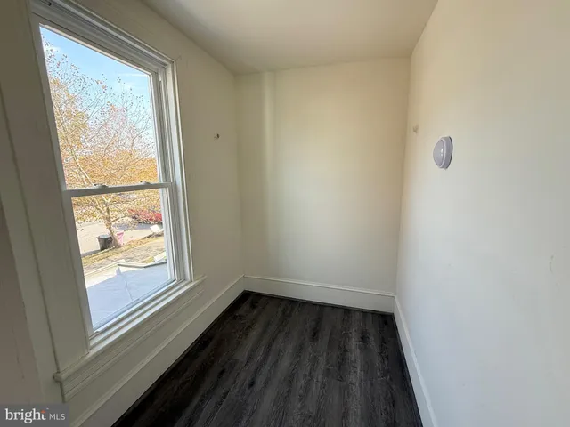 a view of a small space with wooden floor and a window