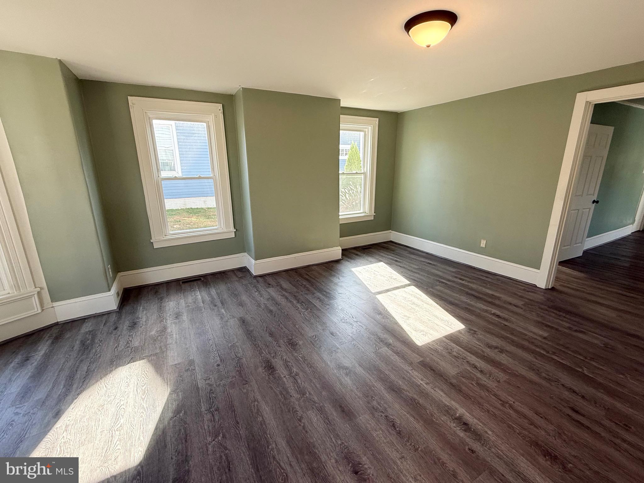 305 Central Avenue Ridgely, MD 21660 - Photo 4 of 19 an empty room with wooden floor and windows