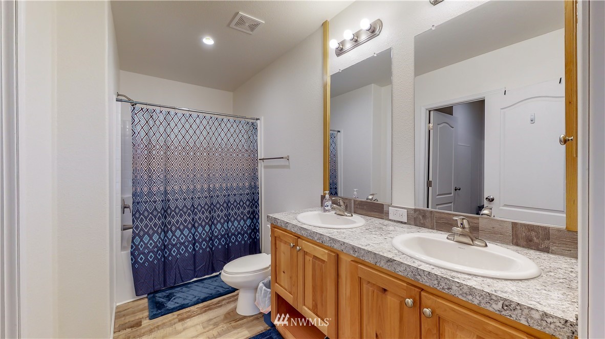 729 Cinebar Road, Unit A Cinebar, WA 98533 - Photo 19 of 30 a bathroom with a granite countertop double vanity sink mirror and toilet