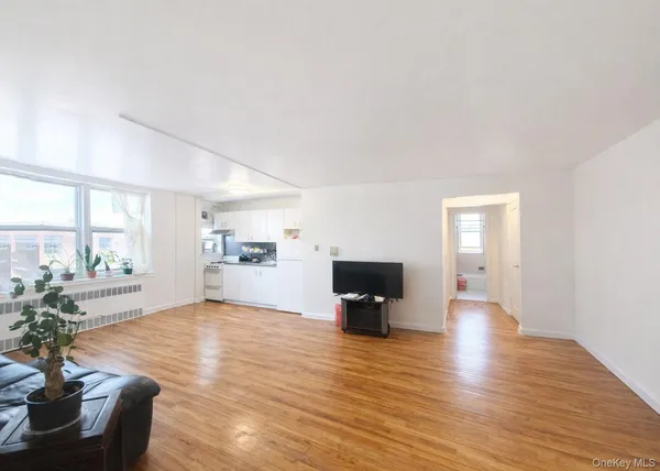 a view of livingroom with kitchen view and wooden floor