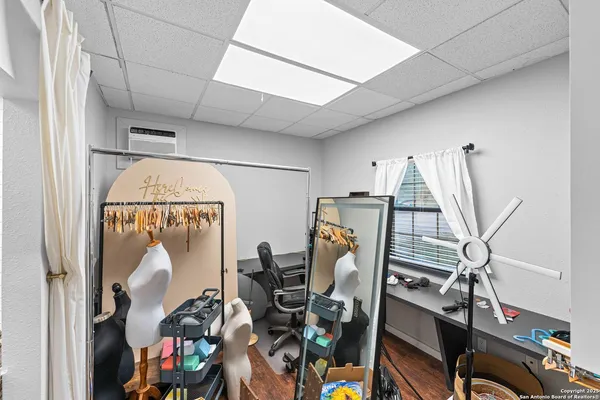 a view of a room with gym equipment and wooden floor