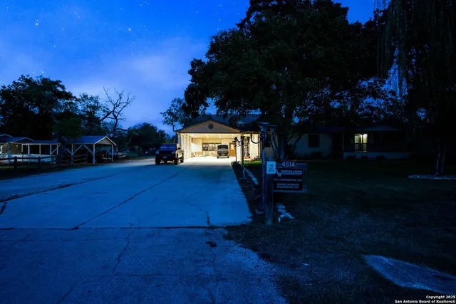 an aerial view of residential houses with outdoor space and trees