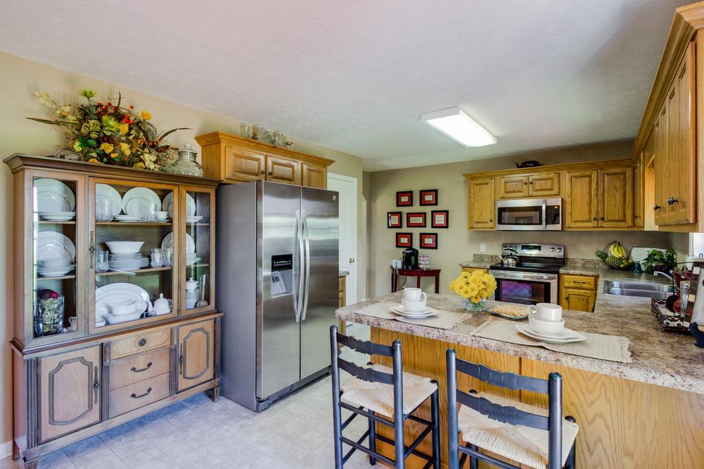 5004 Maple Springs Road Manchester, TN 37355 - Photo 17 of 22 a kitchen with stainless steel appliances granite countertop a refrigerator a stove and a sink with wooden floor