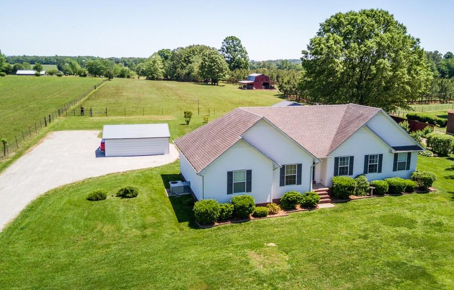 5004 Maple Springs Road Manchester, TN 37355 - Photo 2 of 22 a view of a house with a big yard potted plants and a large tree