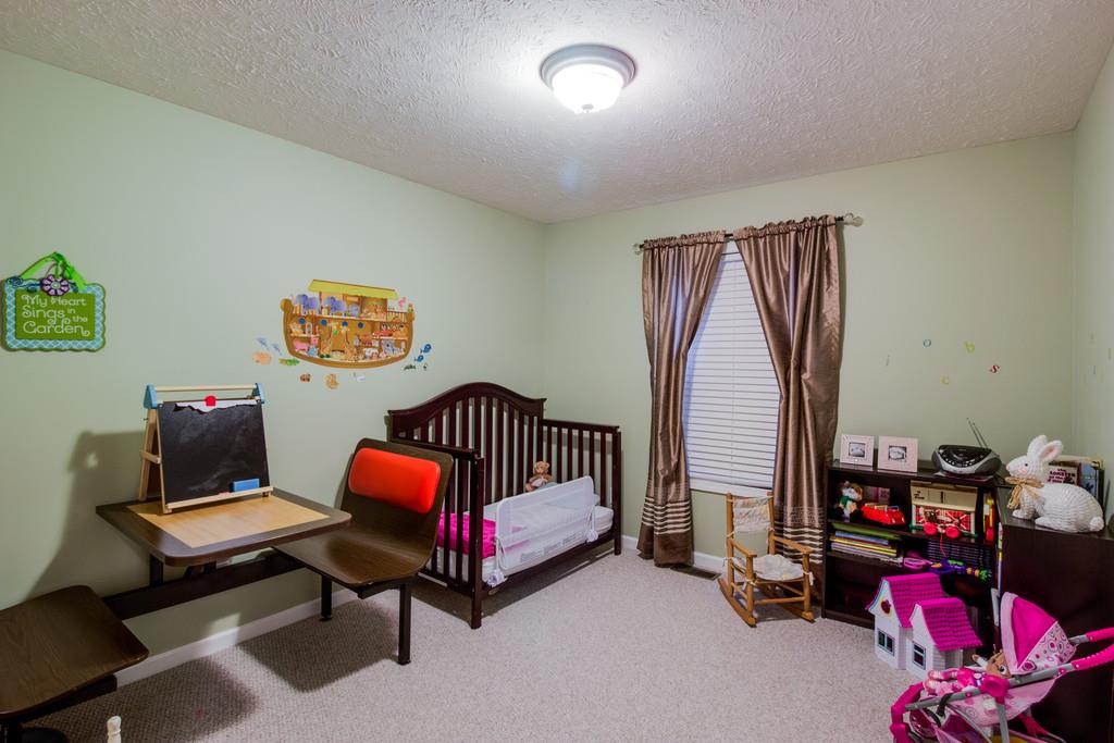 5004 Maple Springs Road Manchester, TN 37355 - Photo 21 of 22 a bedroom with a bed and a chandelier