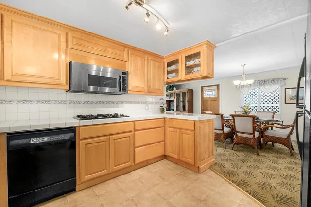 a kitchen with stainless steel appliances granite countertop sink stove top oven and cabinets