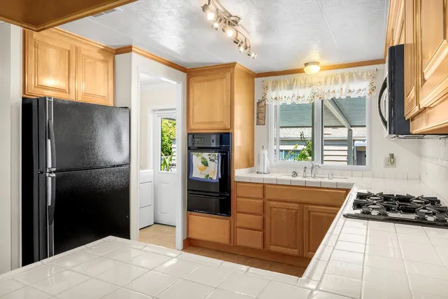 a kitchen with stainless steel appliances a stove a refrigerator and a sink