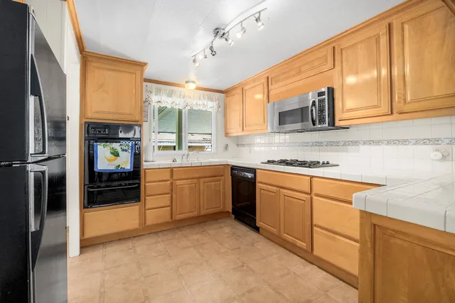 a kitchen with stainless steel appliances granite countertop a refrigerator and cabinets