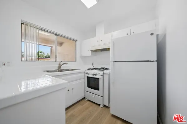 a kitchen with a sink a refrigerator and a stove