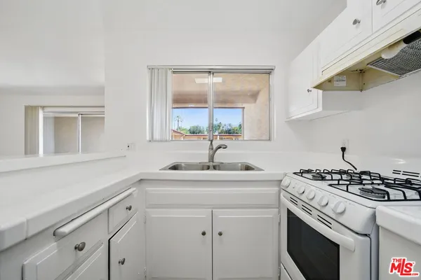 a kitchen with a sink stove and cabinets