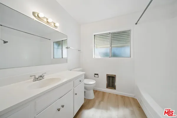 a bathroom with a sink a toilet and a mirror