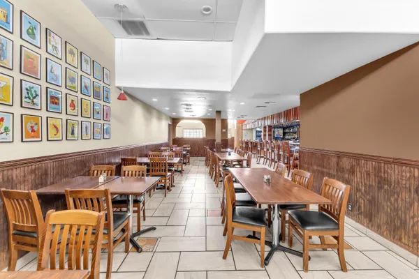 a dining hall with stainless steel appliances kitchen island granite countertop a table and chairs