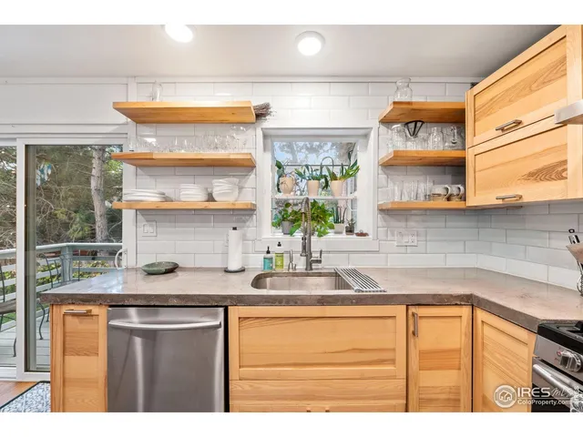 a kitchen with stainless steel appliances granite countertop a sink window and cabinets