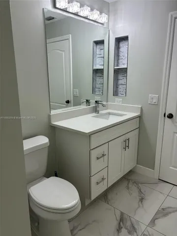 a bathroom with a toilet sink and mirror