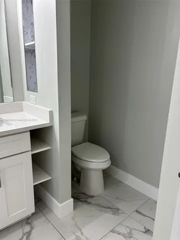a white toilet sitting next to a bathroom sink