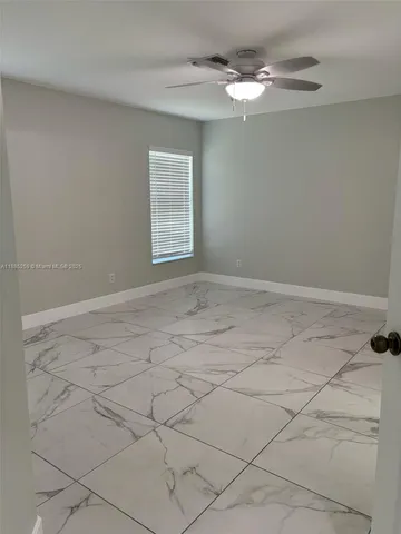 a view of a livingroom with a chandelier fan and window