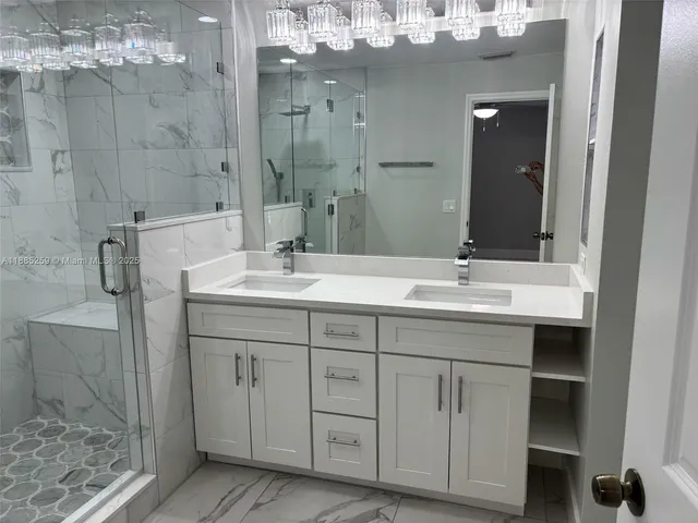 a bathroom with a double vanity sink mirror and shower