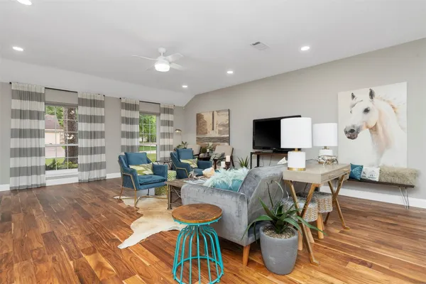 a living room with furniture a flat screen tv and a large window
