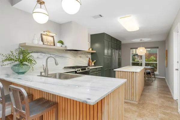 a kitchen with stainless steel appliances granite countertop a sink a stove and a refrigerator