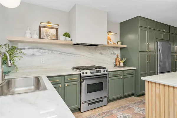 a kitchen with granite countertop a sink stove and refrigerator