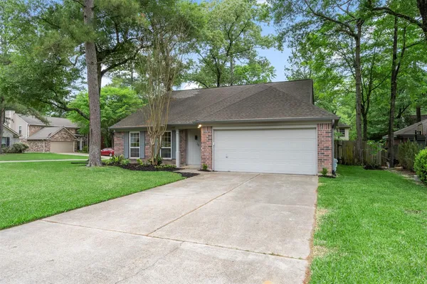 a front view of a house with a yard and trees