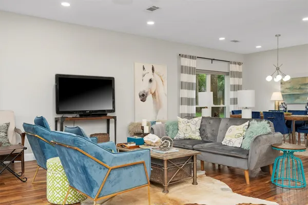 a living room with furniture a flat screen tv and a large window