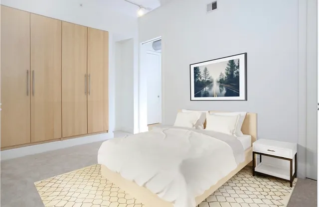 a bedroom with a bed and a painting on the wall