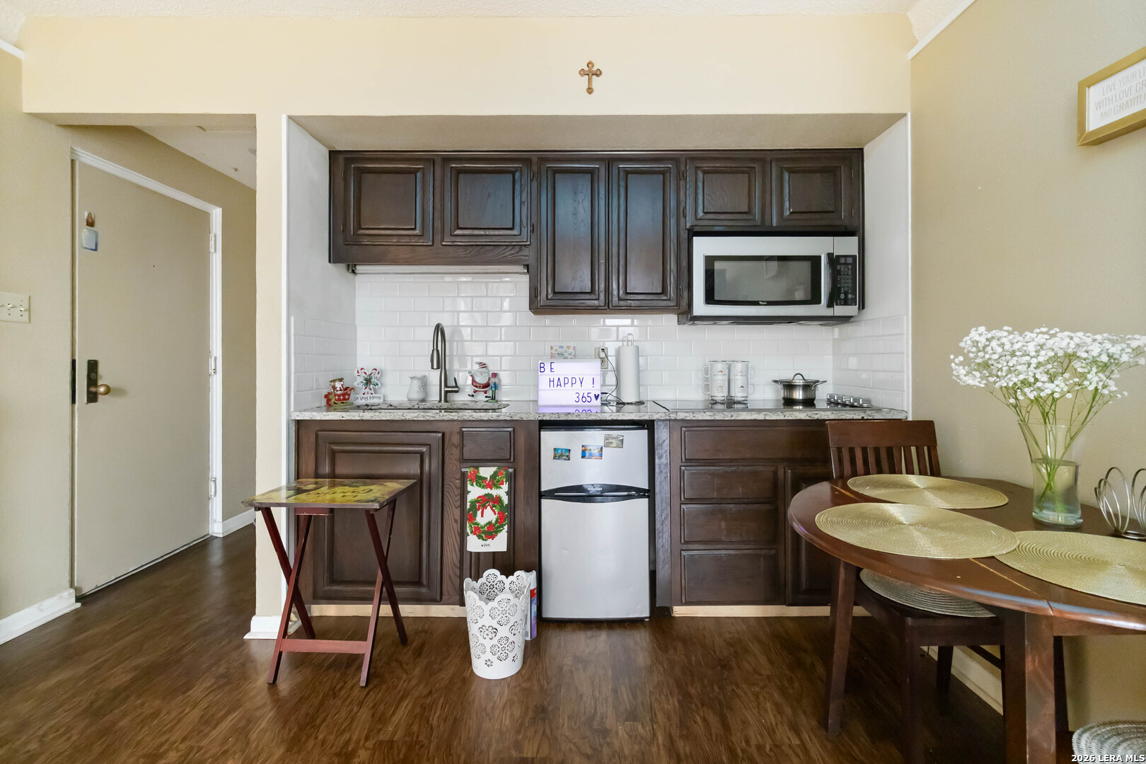 7701 Wurzbach Road, Unit 308 San Antonio, TX 78229 - Photo 5 of 17 a kitchen with a table chairs refrigerator and microwave