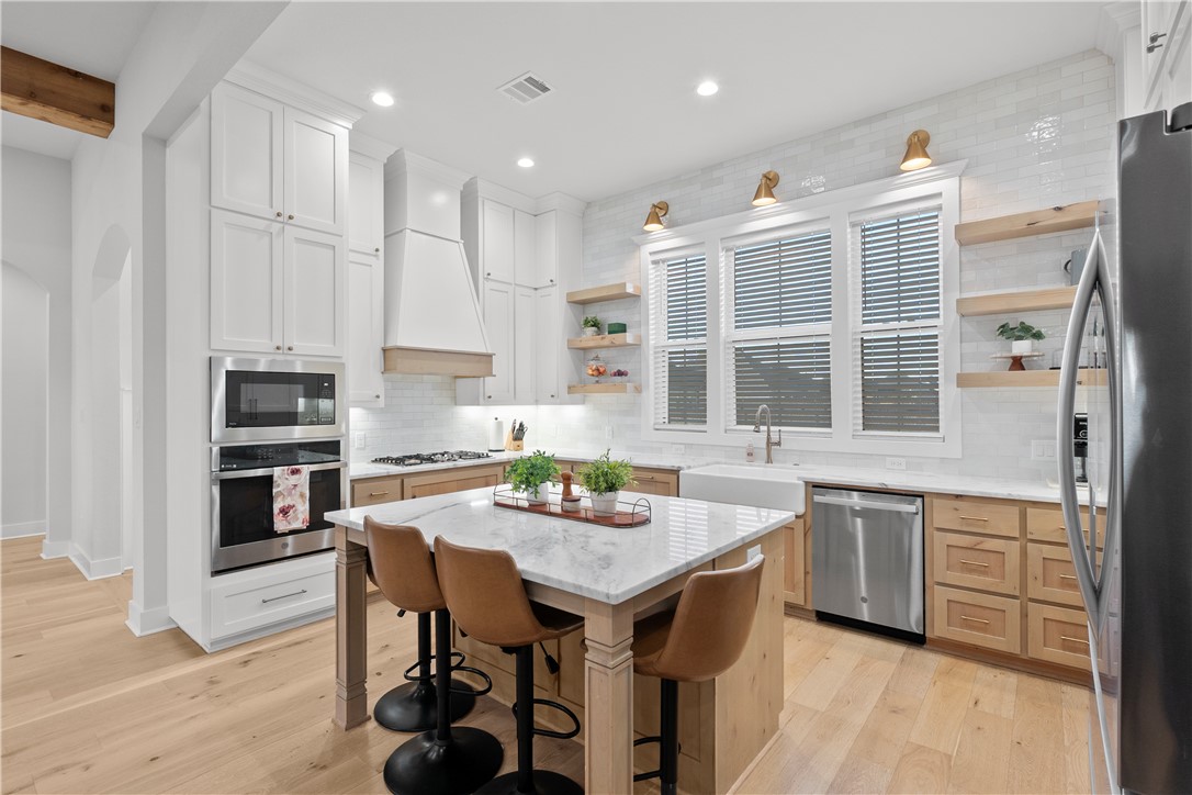 5001 Greenstone Way Bryan, TX 77802 - Photo 12 of 43 a kitchen with stainless steel appliances granite countertop a stove and white cabinets